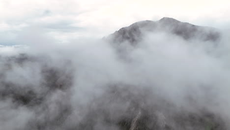 high angle aerial above thin clouds over iconic flatirons in boulder, colorado