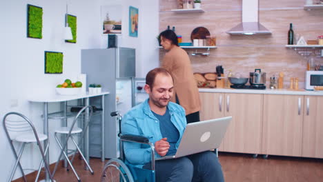 hombre discapacitado en silla de ruedas usando una computadora portátil