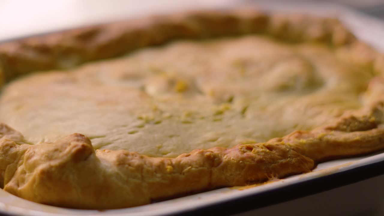 Side View Slow Motion of Homemade Deep Filled Shortcrust Chicken Mushroom Vegetable Pie with Golden Textured Pastry. Comforting British Tasty Delicious Food.