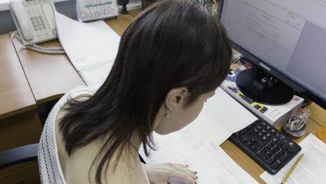 woman reviewing documents at her desk