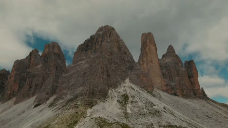 drone de seguimiento filmado con altas montañas rocosas empinadas y cielo parcialmente nublado en el fondo, grado de color cinematográfico