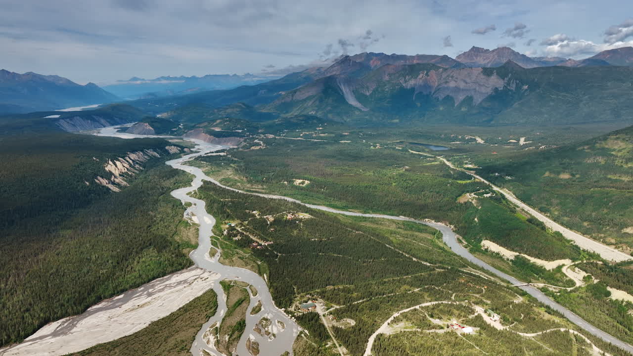 Alaska river winding through forest. Aerial river winding through dense Alaskan forest and mountain terrain