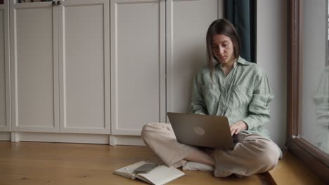 mujer trabajando desde casa en una computadora portátil