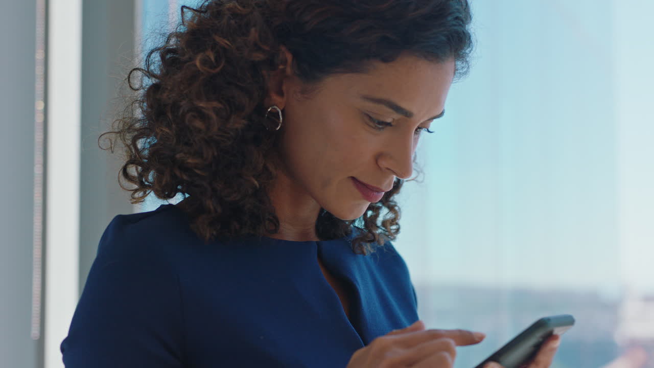 business woman using smartphone texting female executive checking emails browsing messages on mobile phone in office