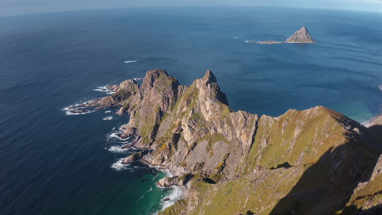 Tourist waving with dog on Måtinden mountain, ocean view in the background