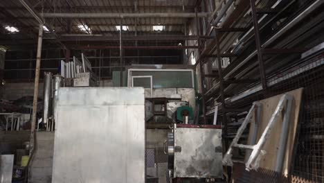 interior view of a cluttered industrial metal workshop or warehouse