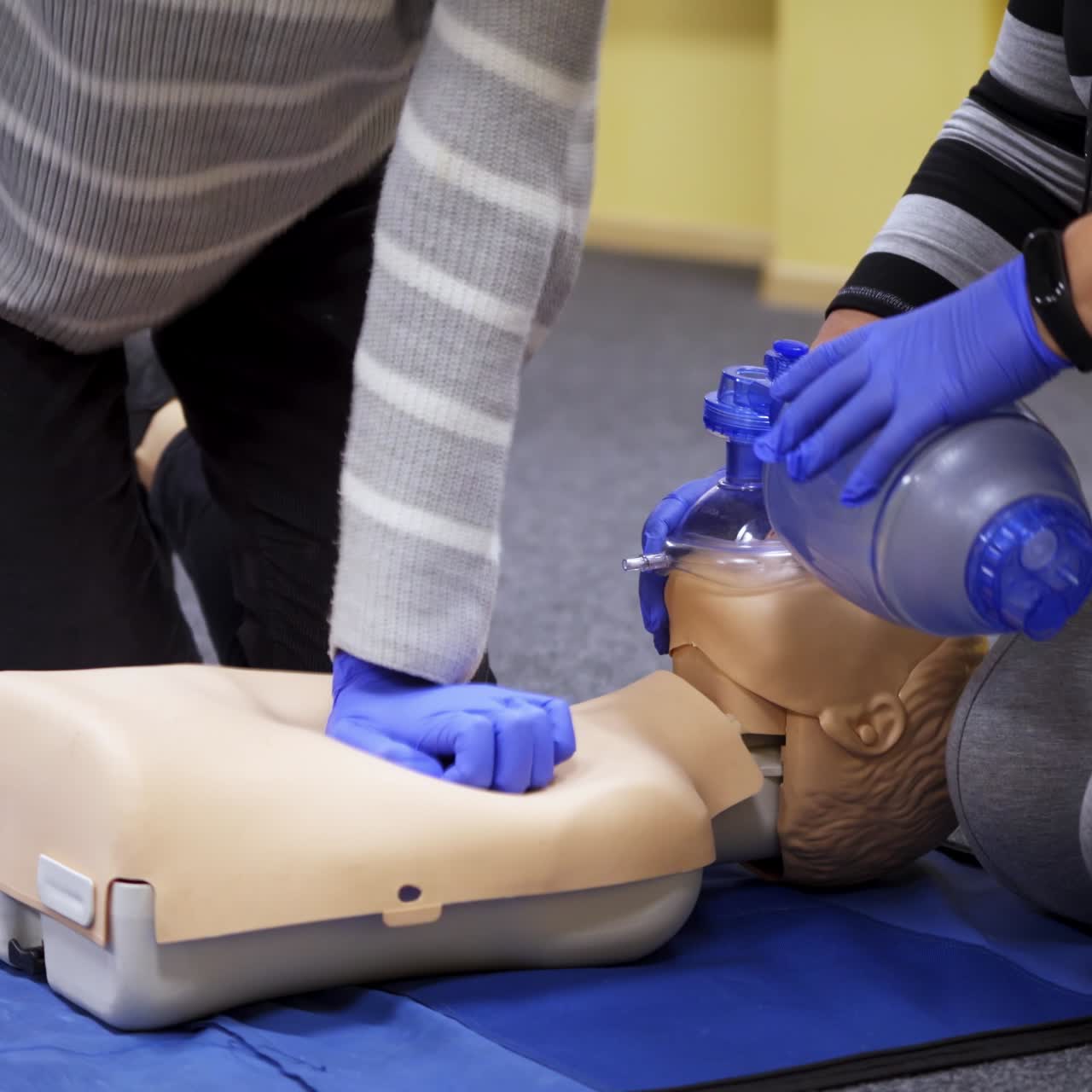 Dummies for medics used for first aid training. Experienced unrecognizible doctor gives recommendations. Oxygen mask on medical doll