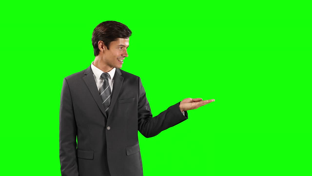 Vista laterale di un uomo caucasico che tiene la mano per uno spazio per il testo con schermo verde