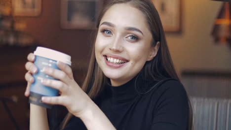 Young-and-beautiful-girl-with-blue-eyes-sitting-in-cafe-with-cup-of-coffee