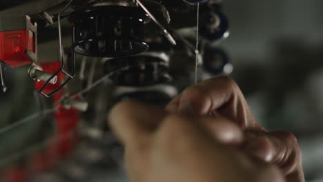 factory worker replaces a broken thread on a cotton textile knitting machinery in a factory in china