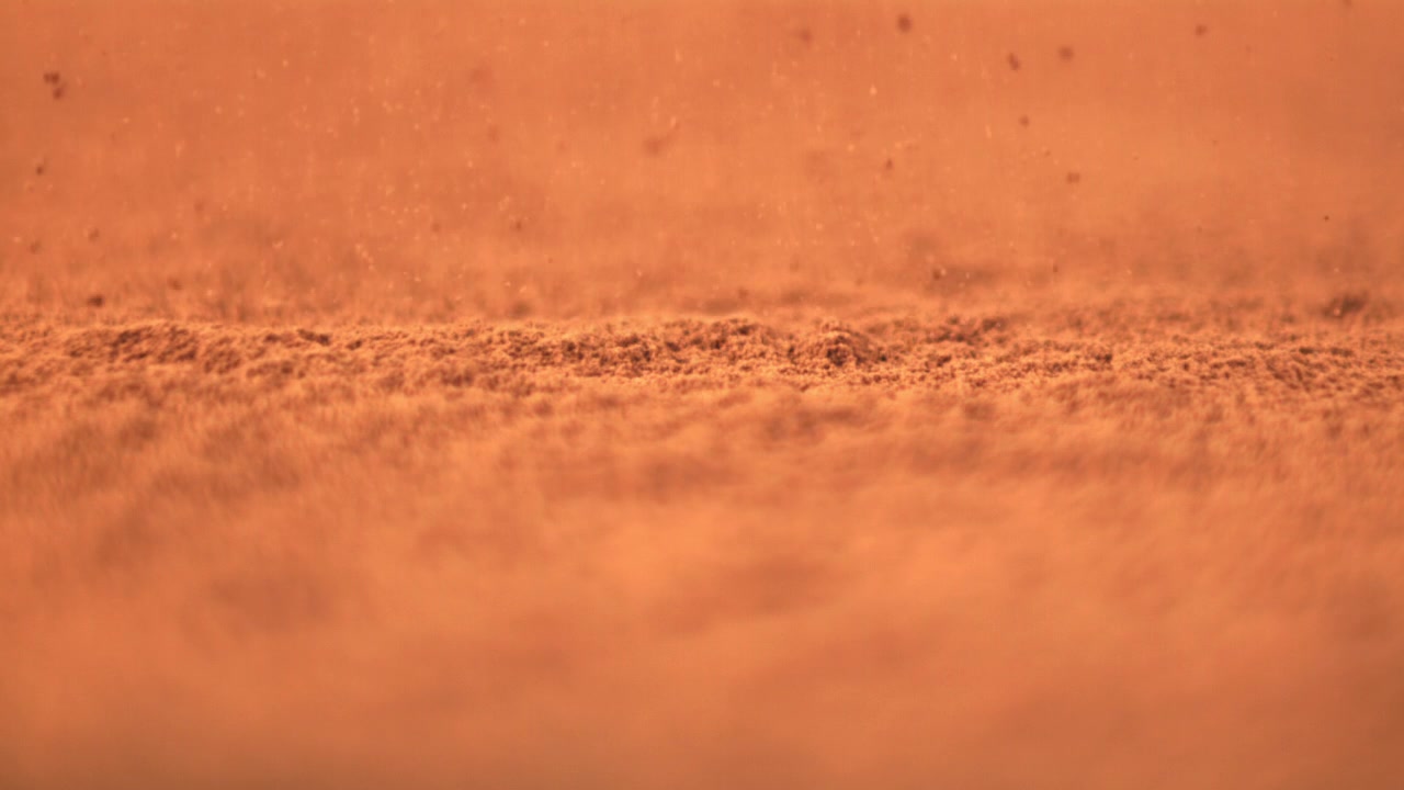 Primo piano di fini particelle di polvere arancione in caduta