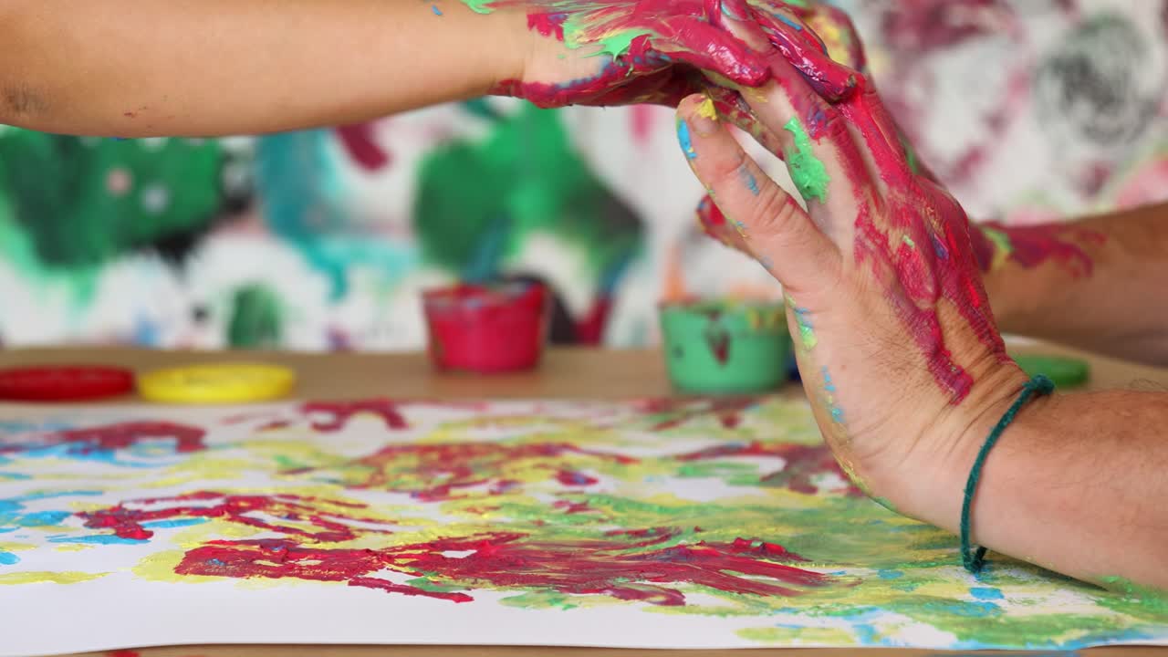 manos de adultos y niños con pinturas de colores listas para la huella de la mano