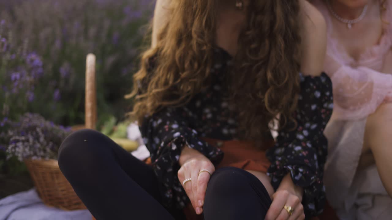 라벤더 필드에서 두 명의 곱슬머리 여성이 검은색 양말을 입고 있습니다.