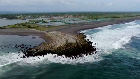 Oceanside-Pier-Und-Salzteiche-An-Der-Küste-Am-Strand-Von-Glagah,-Java,-Luftbogenaufnahme