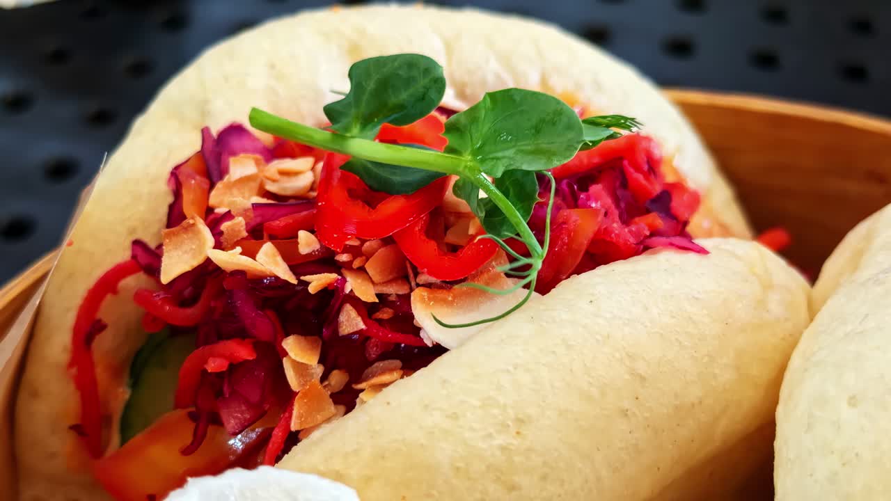 Primo piano di bao bun al vapore ripieni di verdure colorate e arachidi