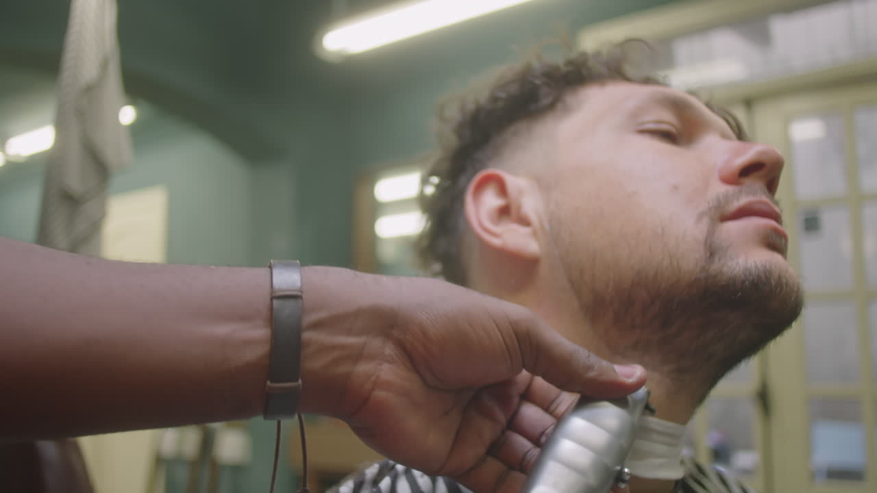 Man Getting His Beard Neckline Shaved in Barbershop