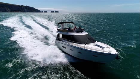 luxury motorboat with needles in the background, drone tracking shot