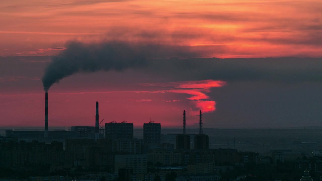 Elevated view with sunrise over the city center with smoking pipes and central business district Timelapse from rooftop, Kazakhstan, Astana, Central Asia