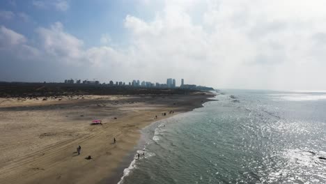 Flying-along-Mediterranean-Sea-coast-and-beach-in-Hadera-park,-Israel