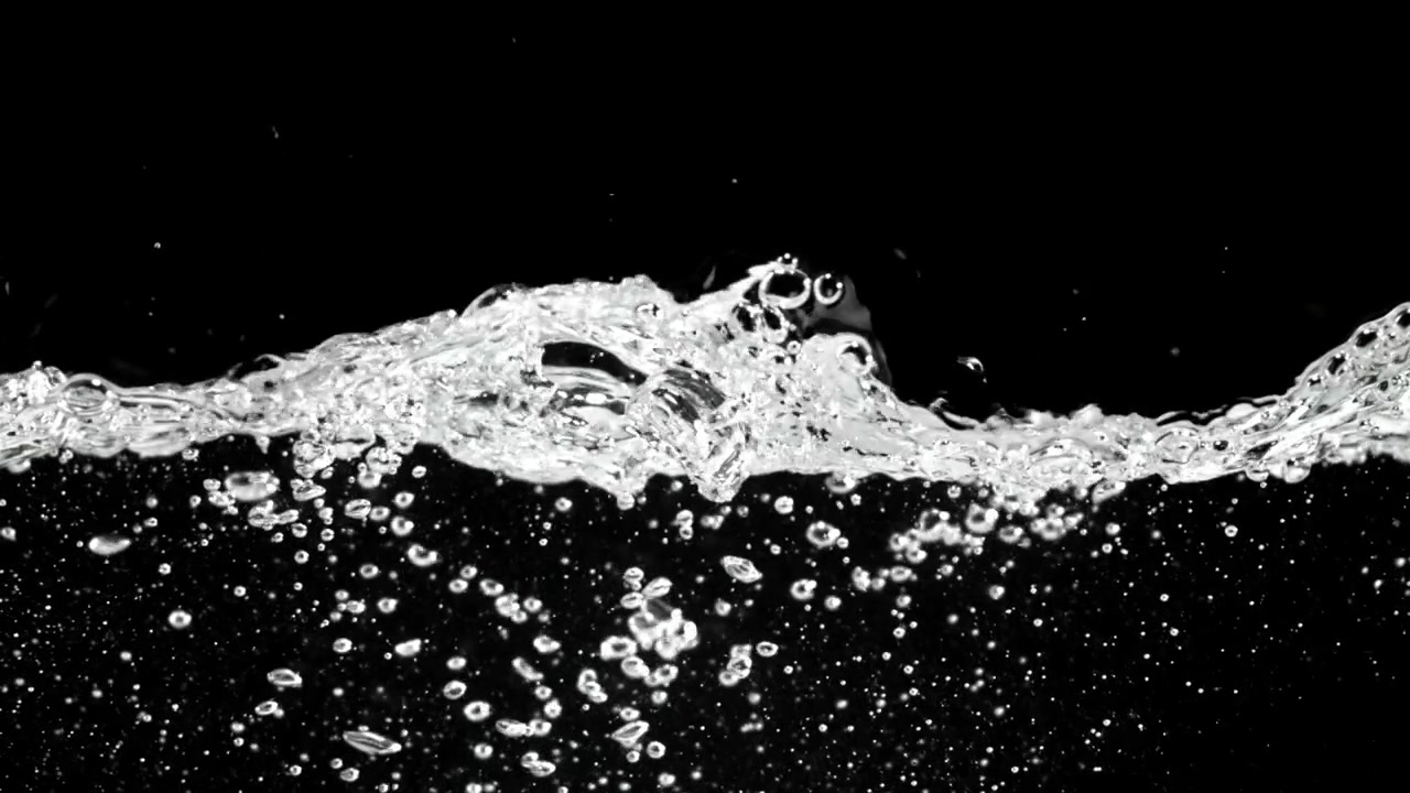 Klare Wasseroberfläche mit Blasen und Wellen auf schwarzem Hintergrund