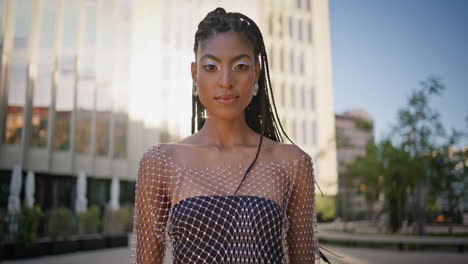 cosmic  woman looking camera at sunny downtown portrait. dreadlocks lady