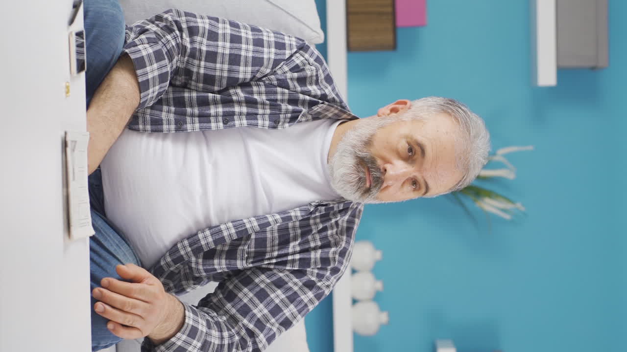 Vertical video of The emotional old man gets sad.