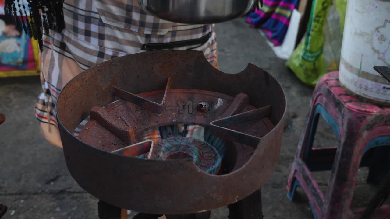 cocinero tailandés encendiendo un quemador de gas y poniendo una olla encima para hacer sopa