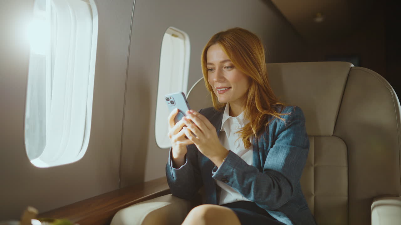 Businesswoman using smartphone on airplane
