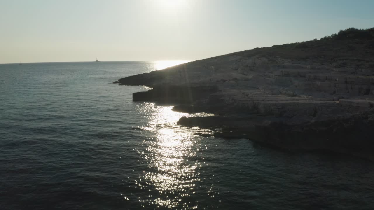 amplia toma aérea de una hermosa costa con luz de fondo del sol