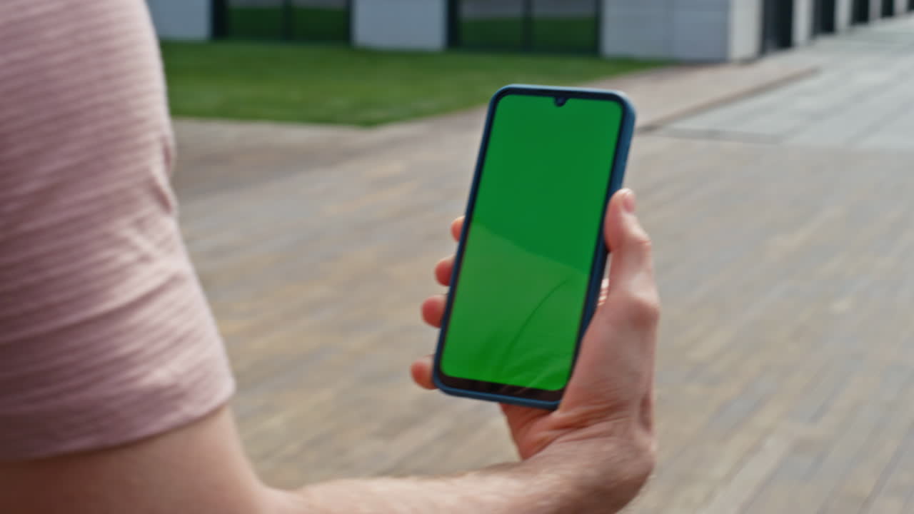Walking man looking chroma key cellphone at street closeup. Unrecognizable man