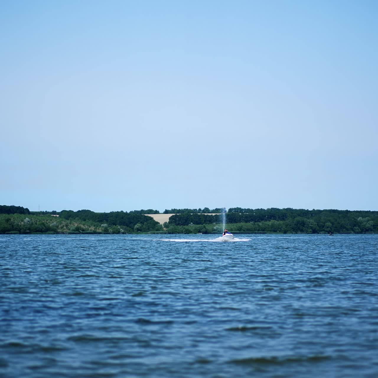Jet ski riding by the river on sunny day. Summer time activities on water. Extreme water sport