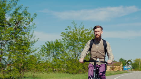 Un-Joven-Barbudo-Está-Montando-Una-Bicicleta