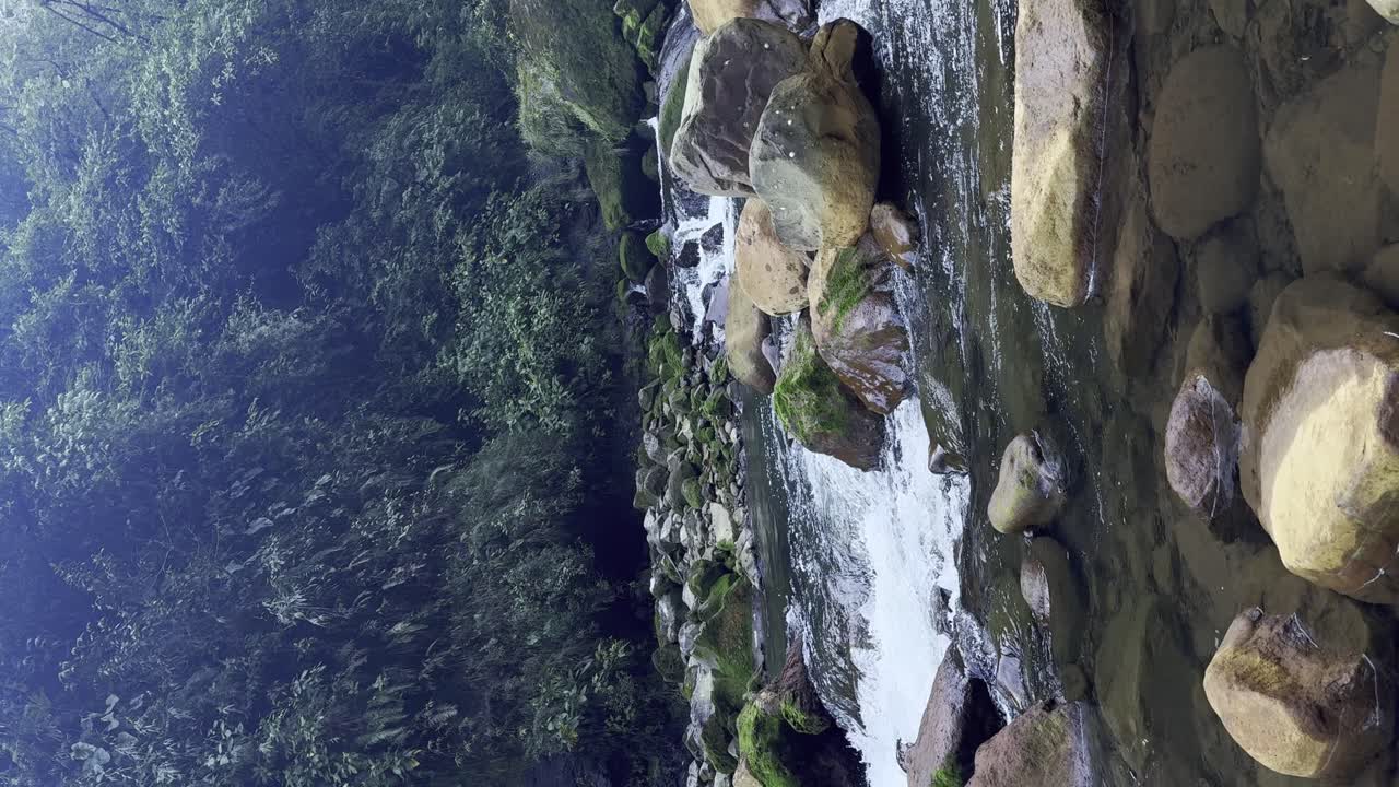 Peaceful river running between muddy stones