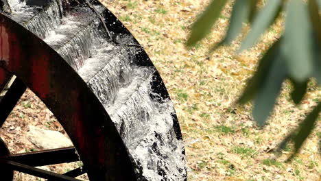 el agua fluye en cámara lenta sobre la vieja rueda de agua disparada a 180 fps