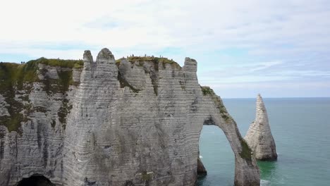 flying around the rocky arch of etretat in france on the coast of normandy