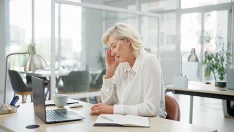 stressed senior businesswoman with headache in office