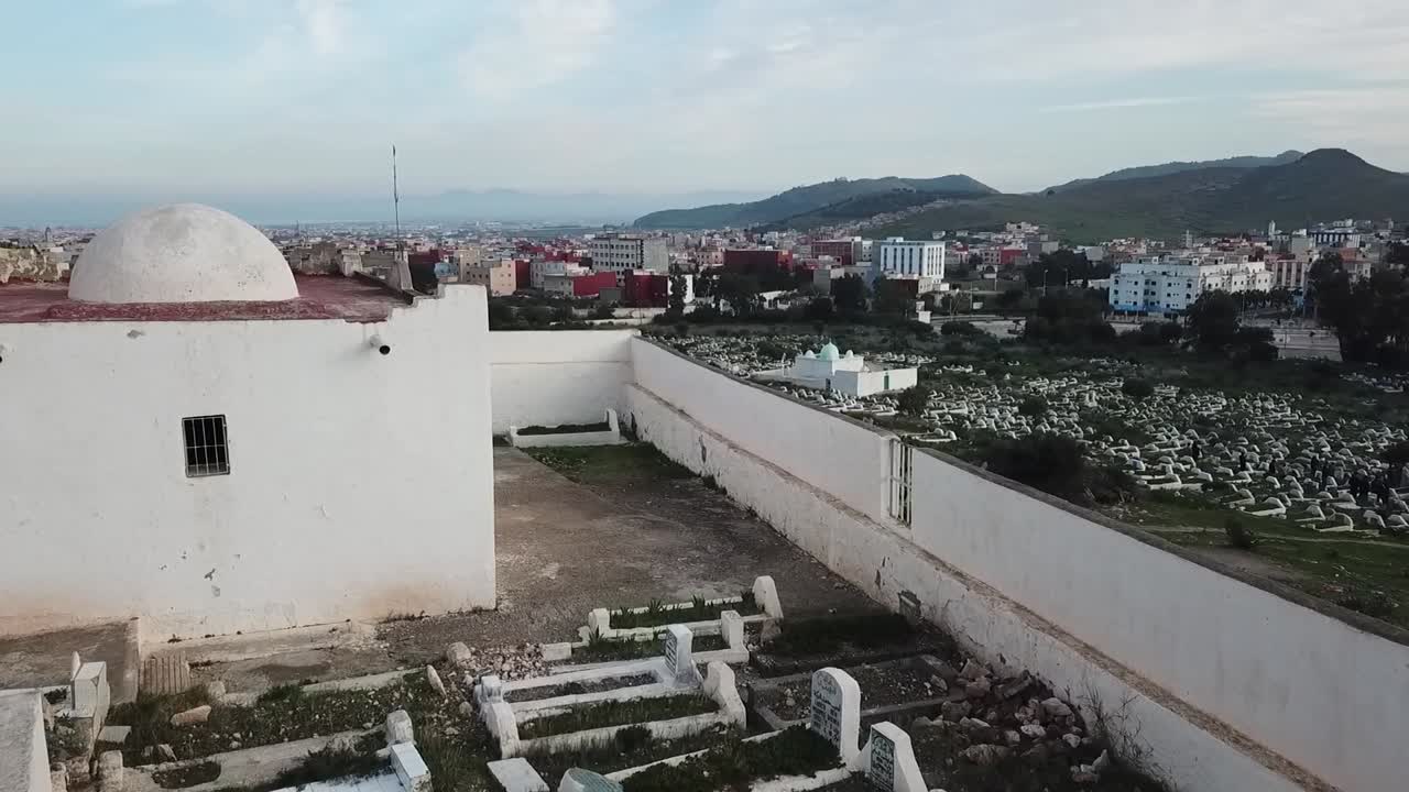 Ripresa aerea che mostra la corte di un tradizionale santuario islamico bianco (Marabout), con antiche tombe racchiuse tra le mura bianche in Marocco