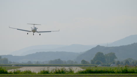 Rear-view-of-light-airplane-landing-and-starting-again-with-swiss-alps-in-background