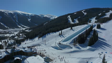 Drone-aerial-Copper-Mountain-winter-ski-snowboard-resort-half-pipe-training-practice-tricks-competition-Colorado-early-morning-sunlight-fresh-snow-unique-birds-eye-cinematic-backwards-motion-4k