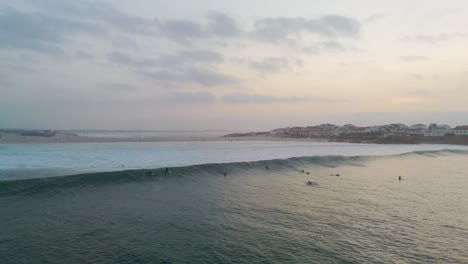 surfers waiting for the perfect wave at sunset