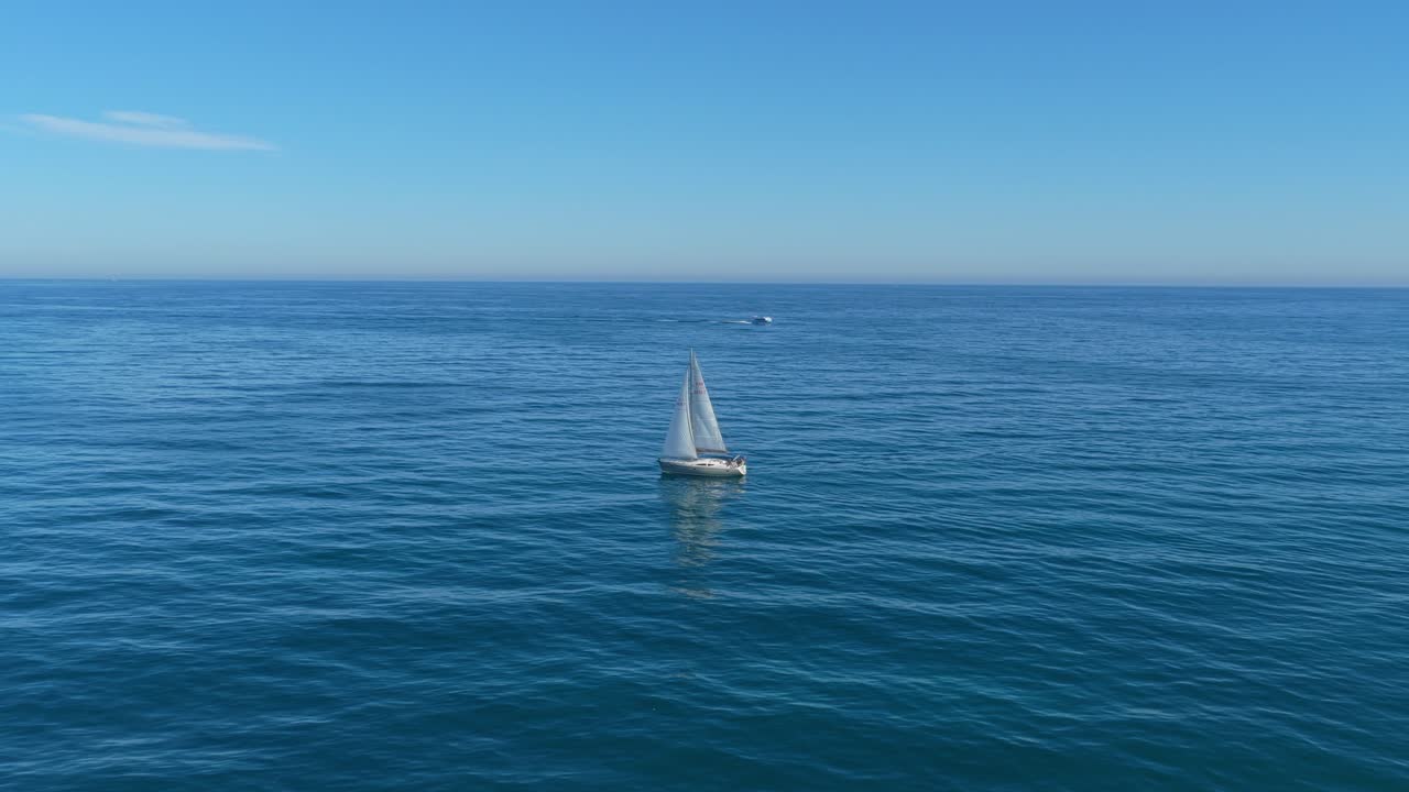 Veleiro branco navegando em mar azul aberto