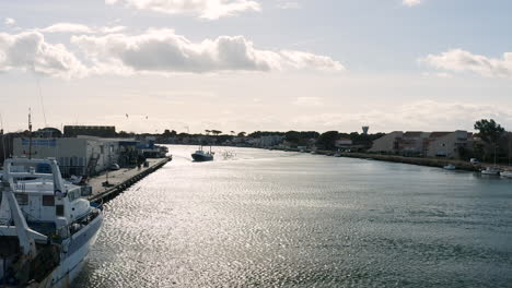 Fishing-boat-arriving-in-Grau-d'adge-auction-fish-market-aerial-drone-shot-sunny