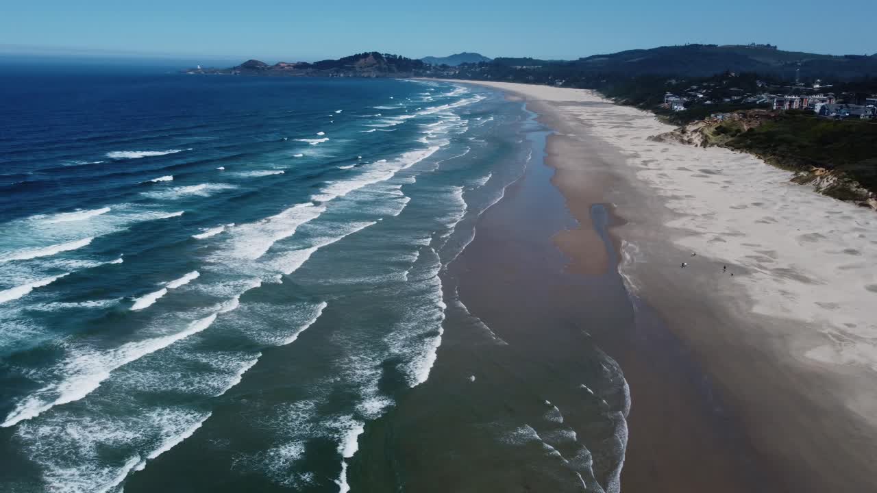 toma de drones en el sentido de las agujas del reloj de olas rompiendo en nye beach, una playa en la pequeña ciudad de newport en la costa de oregon