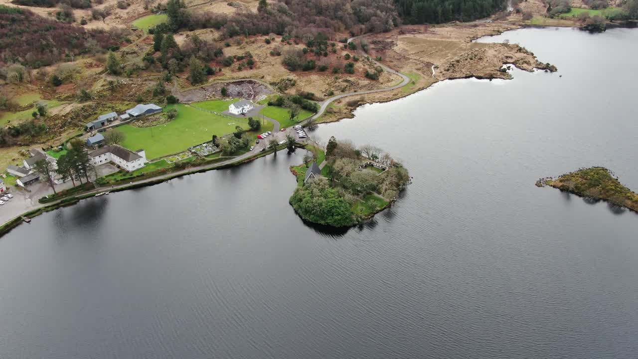 Drone circling island jetting out in lake at Gougane National Park, Ireland