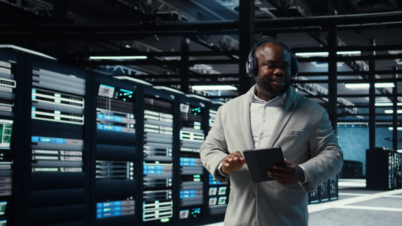 Vertical video Data center admin wearing headphones using tablet to identify bottlenecks