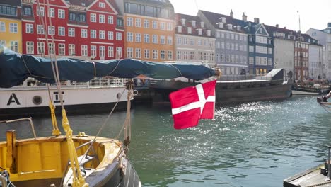 Danish-flag-waving-in-the-wind-at-Nyhavn,-Copenhagen