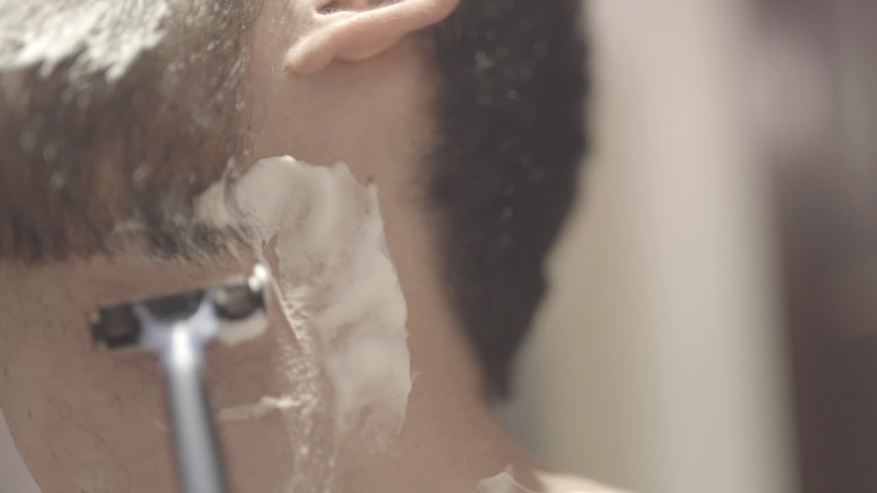 primer plano hombre blanco afeitándose la barba, baño, tiro estático