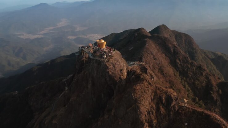Panoramica attorno alla cima della montagna con un ponte di vetro e un'attrazione turistica in cima