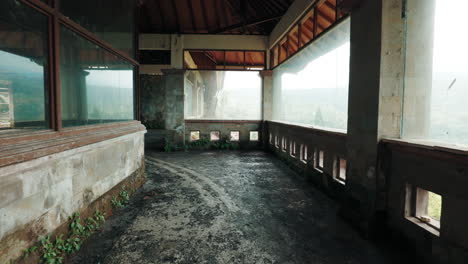 abandoned building interior overlooking a misty landscape