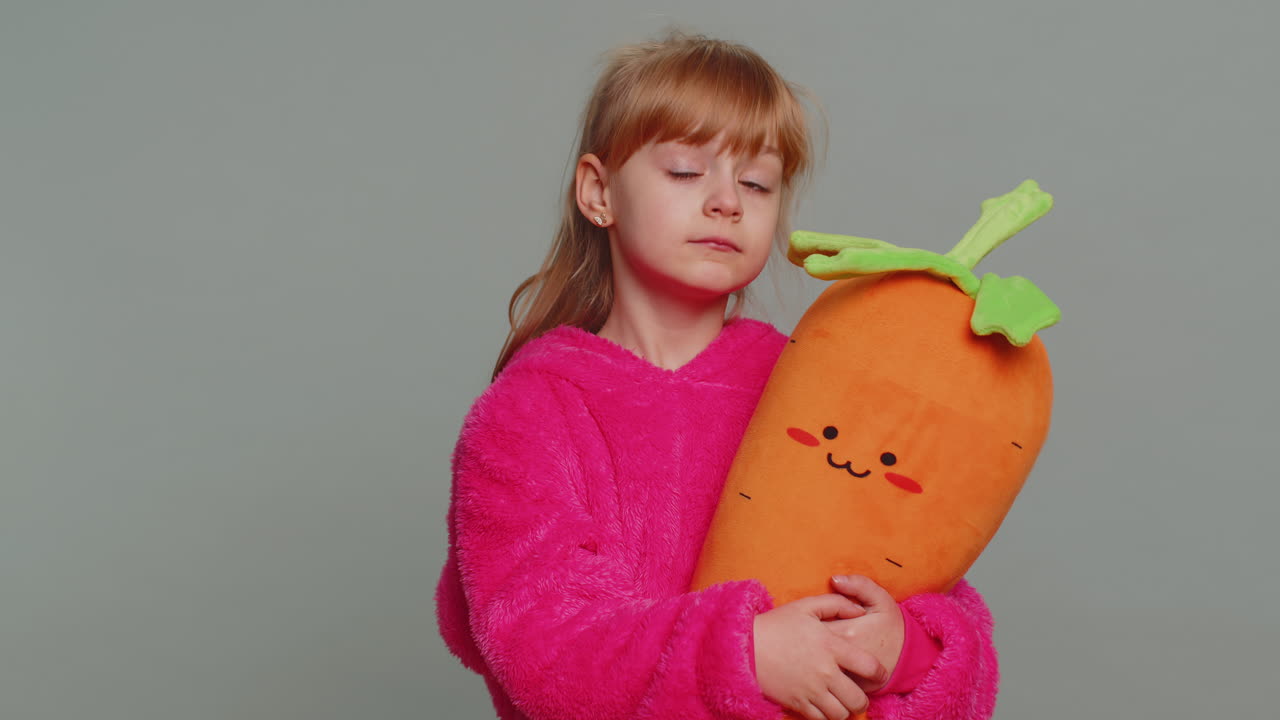 молодая девушка с плюшевой игрушкой из моркови и улыбается